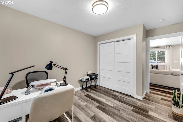 home office with wood-type flooring and a textured ceiling