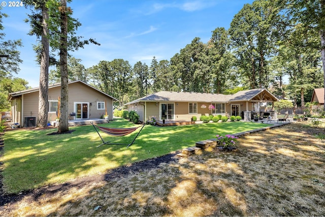 rear view of property with central AC unit, a lawn, and a deck