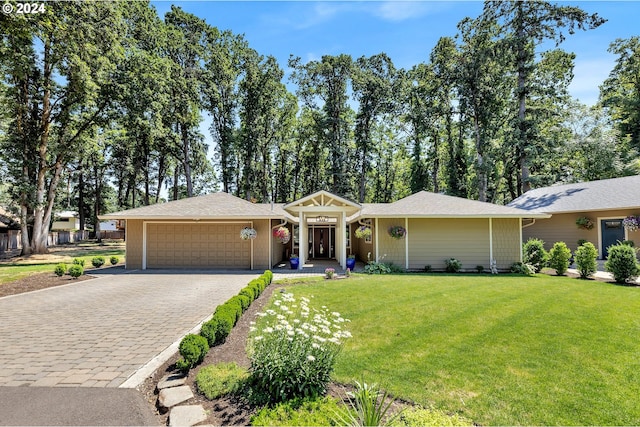 ranch-style house featuring a garage and a front lawn