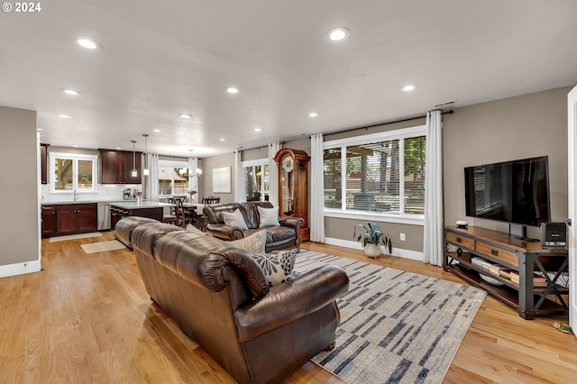 living room with a chandelier and light hardwood / wood-style flooring