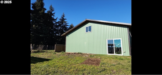 view of home's exterior with a lawn and fence