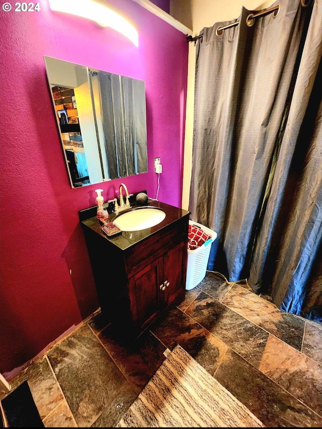 bathroom with vanity, curtained shower, and stone tile flooring
