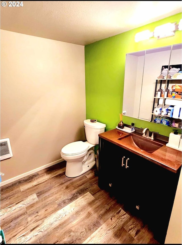 bathroom featuring vanity, wood finished floors, and toilet
