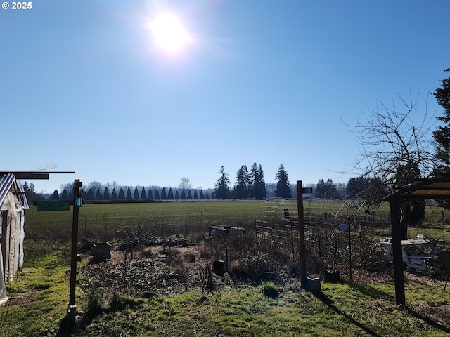 view of yard featuring fence and a rural view