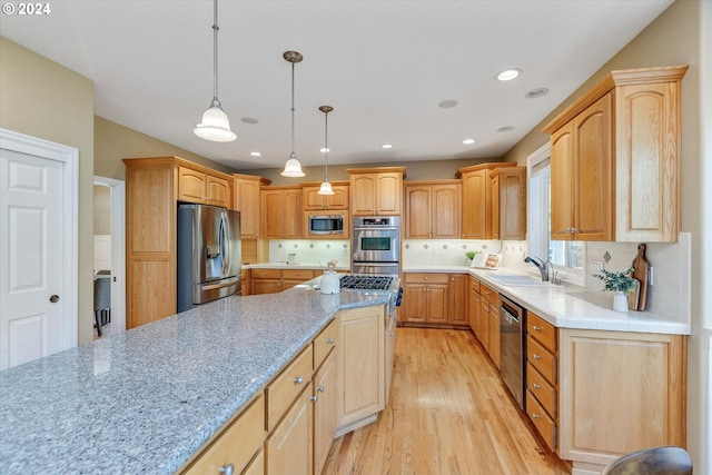 kitchen with backsplash, pendant lighting, stainless steel appliances, light hardwood / wood-style flooring, and sink