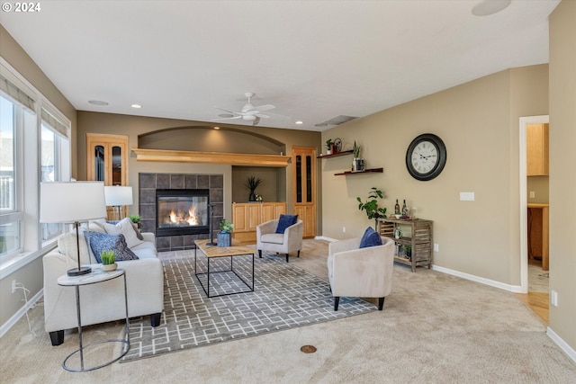 living room with light carpet, ceiling fan, and a fireplace