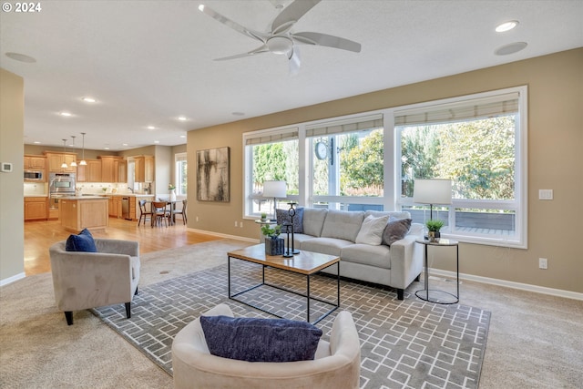 carpeted living room with ceiling fan