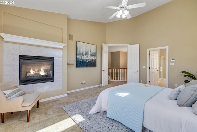 carpeted bedroom featuring a high ceiling, a fireplace, and ceiling fan