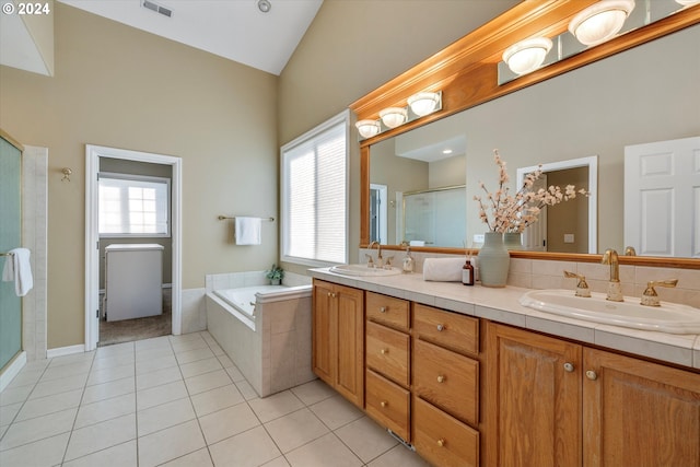 bathroom featuring vanity, high vaulted ceiling, plus walk in shower, and tile patterned floors