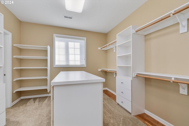 walk in closet with light wood-type flooring