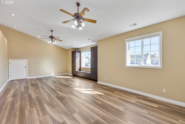 empty room featuring light wood-type flooring, ceiling fan, and a textured ceiling