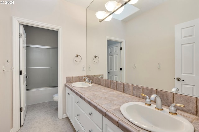 full bathroom featuring enclosed tub / shower combo, vanity, and toilet