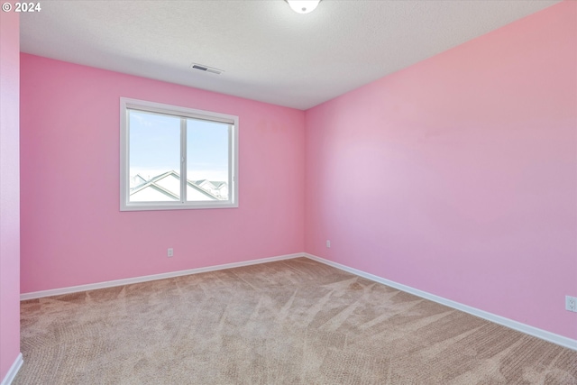 spare room with a textured ceiling and light colored carpet