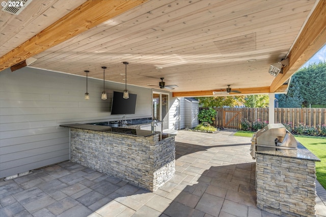 view of patio featuring ceiling fan and exterior kitchen