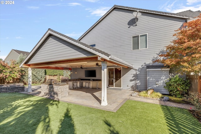 rear view of property featuring ceiling fan, a lawn, and a patio area