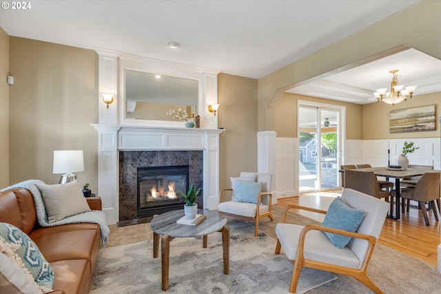 living area featuring a notable chandelier, a fireplace, and light hardwood / wood-style floors