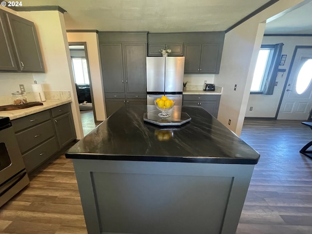 kitchen with a healthy amount of sunlight, gray cabinetry, stainless steel appliances, and a center island