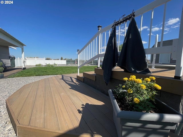 deck featuring fence, stairway, and a lawn