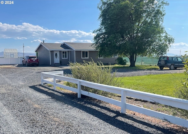 single story home featuring fence, driveway, and a front lawn