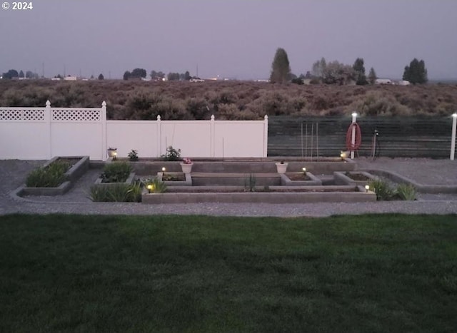 exterior space featuring a garden, fence, and a rural view