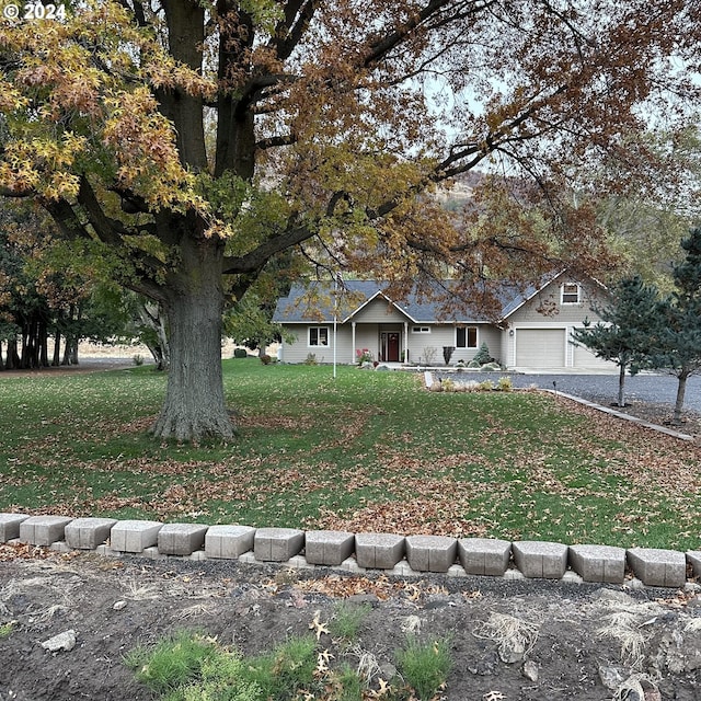 view of front of home with a front yard and a garage