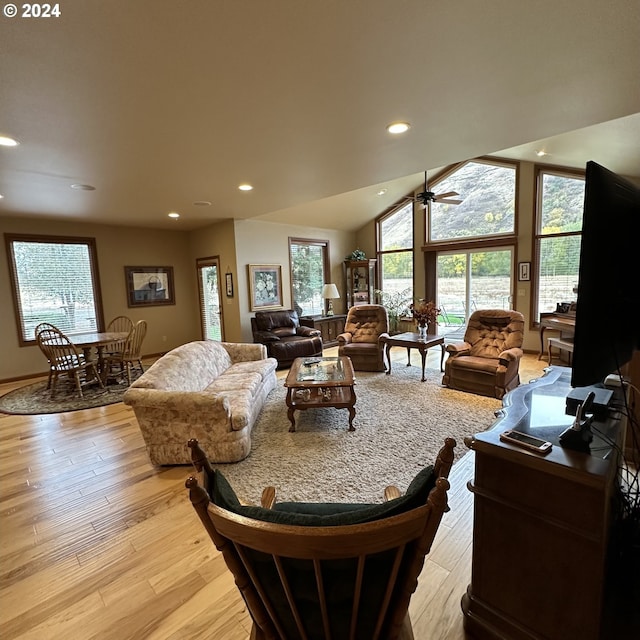 living room with vaulted ceiling, light hardwood / wood-style flooring, and ceiling fan