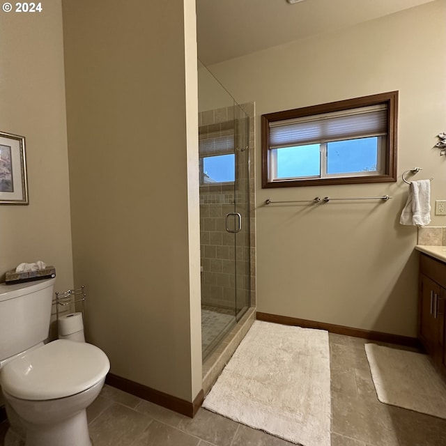 bathroom with tile patterned flooring, vanity, toilet, and a shower with shower door