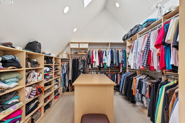 spacious closet with lofted ceiling with skylight and light wood-type flooring