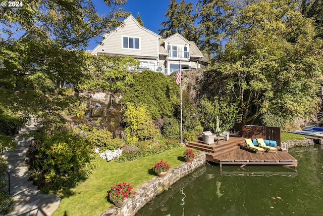 dock area featuring a deck with water view and a yard