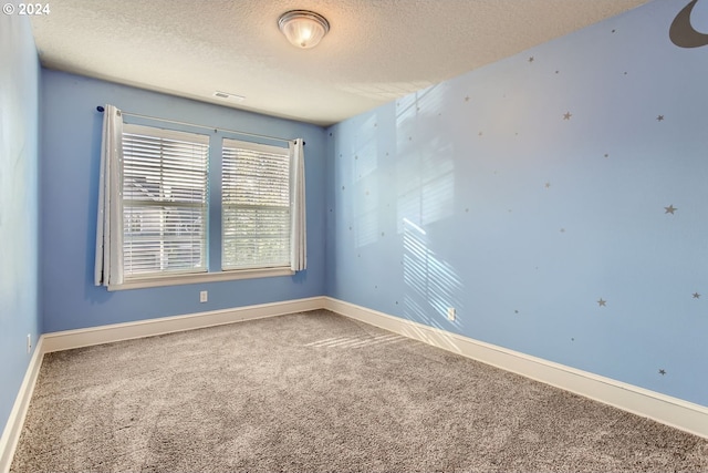 carpeted spare room featuring a textured ceiling