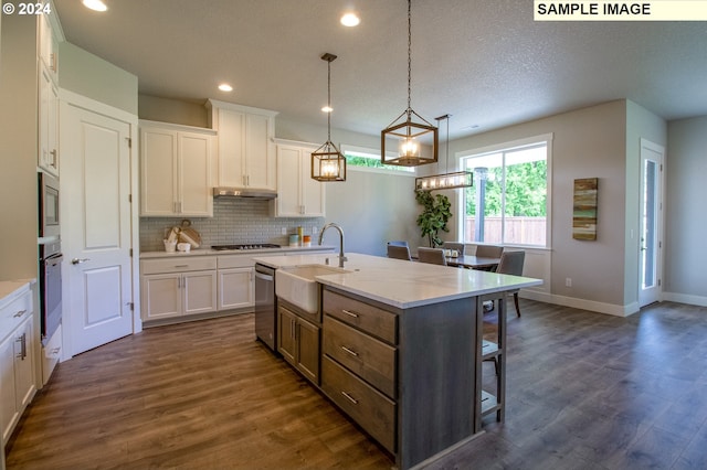 kitchen with sink, dark hardwood / wood-style flooring, a kitchen island with sink, white cabinets, and appliances with stainless steel finishes