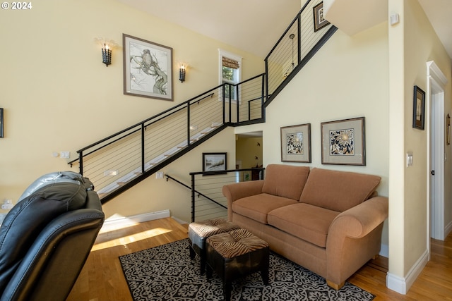 living room with light hardwood / wood-style flooring and a high ceiling