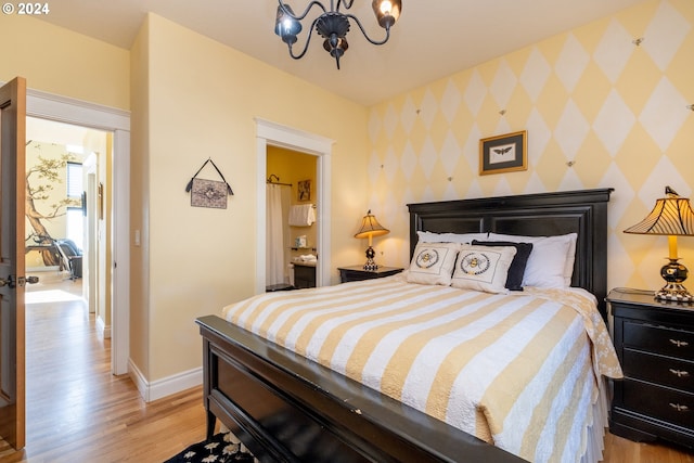 bedroom with light hardwood / wood-style floors and an inviting chandelier