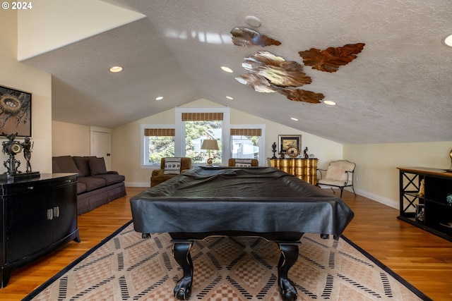 game room featuring light hardwood / wood-style floors, a textured ceiling, pool table, and vaulted ceiling