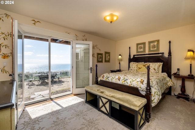 bedroom featuring access to outside and a water view