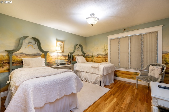 bedroom with hardwood / wood-style flooring and a textured ceiling