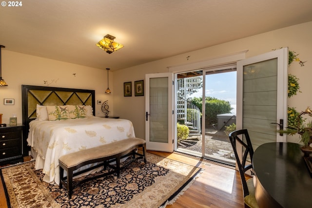 bedroom with hardwood / wood-style floors and access to exterior