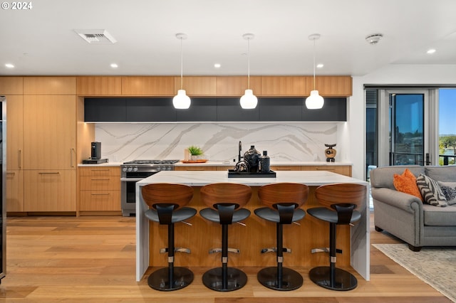 590 Waterfront Way Unit 202, Vancouver, WA 98660 - kitchen with backsplash, light wood-style floors, gas range, modern cabinets, and light countertops