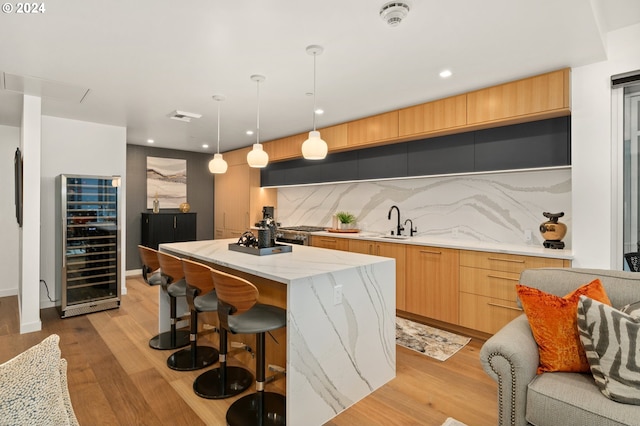 590 Waterfront Way Unit 202, Vancouver, WA 98660 - kitchen featuring a center island, a sink, tasteful backsplash, modern cabinets, and beverage cooler