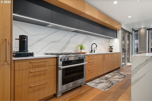 590 Waterfront Way Unit 202, Vancouver, WA 98660 - kitchen featuring high end stainless steel range, light countertops, light wood-style flooring, backsplash, and recessed lighting