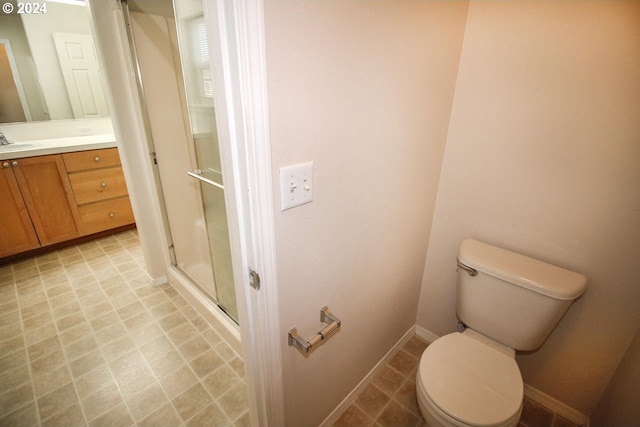 bathroom featuring vanity, toilet, and a shower with shower door