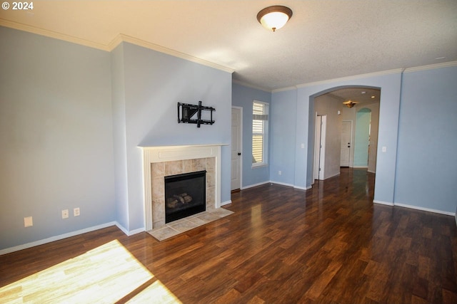 unfurnished living room with a textured ceiling, crown molding, a tile fireplace, and dark hardwood / wood-style flooring