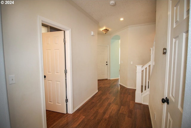 hall featuring dark hardwood / wood-style floors, ornamental molding, and a textured ceiling