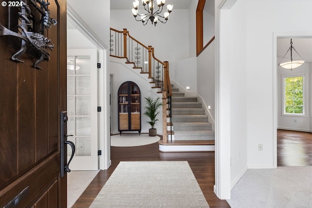 foyer with dark wood-type flooring and an inviting chandelier