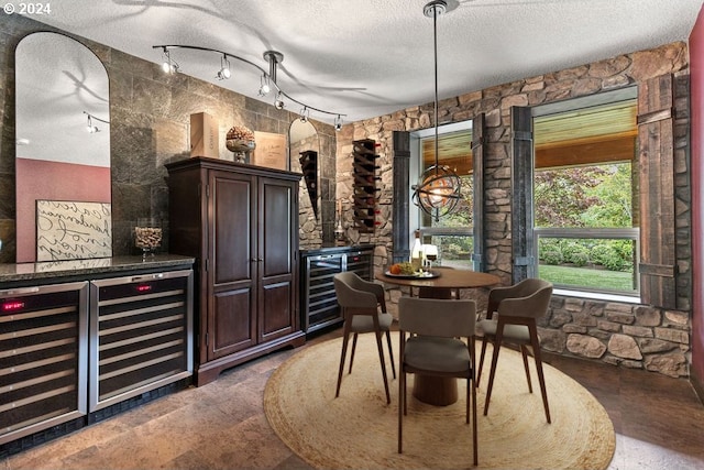 interior space with a textured ceiling, dark brown cabinetry, and beverage cooler