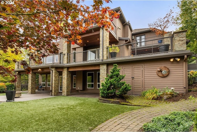 back of house featuring a patio, a balcony, and a yard