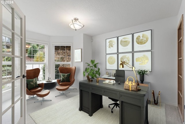 carpeted home office with a textured ceiling