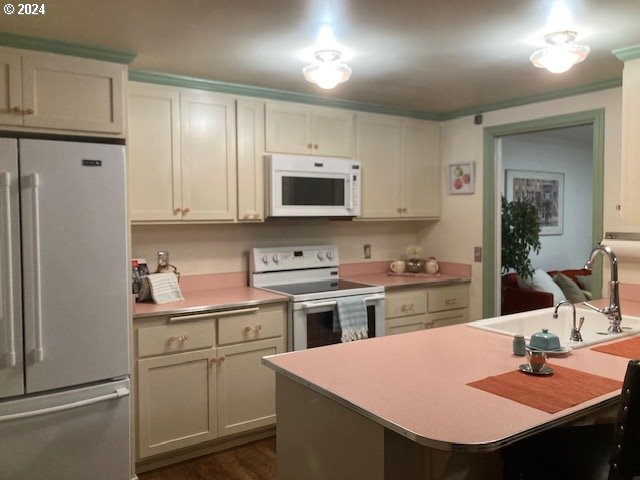 kitchen with white appliances, dark hardwood / wood-style floors, and sink