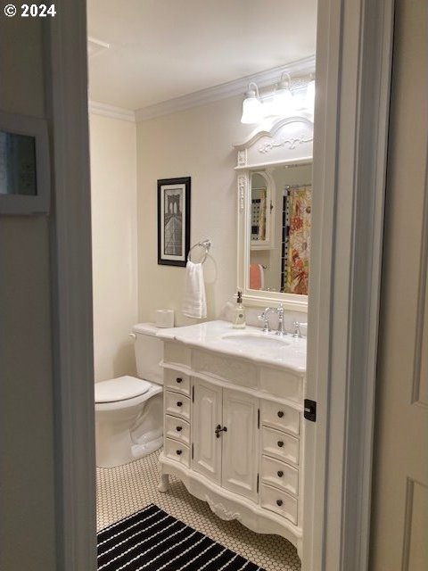 bathroom featuring toilet, vanity, tile patterned floors, and ornamental molding