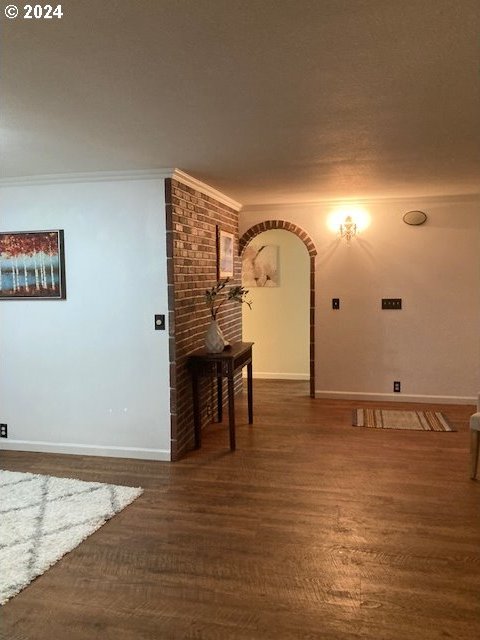 hallway with dark hardwood / wood-style floors and ornamental molding